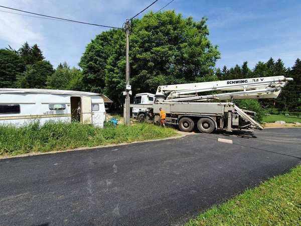 Betonáž základových pásů čerpadlem Schwing – pracovníci usměrňují tok čerstvého betonu z výložníku