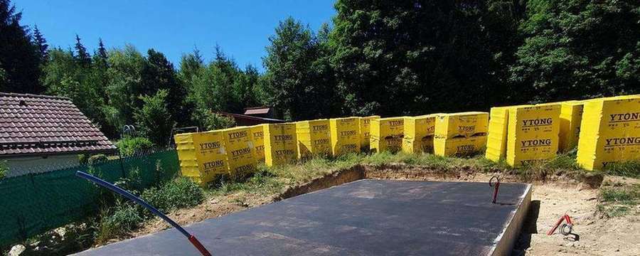 Hotová základová deska s asfaltovou hydroizolací připravená k zahájení zdění