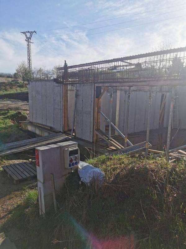 Pohled na monolitické betonové stěny podsklepení s armovacím košem připraveným pro stropní desku a stavební rozvaděč