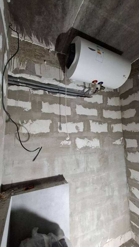 Komponenty koaxiálního dvouplášťového dýmovodu pro kachlová kamna sauny – bílé ocelové roury, kolena, kondenzátní hrnec a nerezový ventilátor připraveny k montáži
