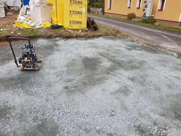 Zpevněný štěrkový vjezd na staveniště – hutnění podkladu vibrační deskou před betonáží