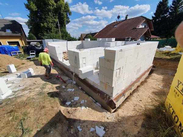 Průčelí rozestavěného domu s otvory pro okna a dveře – zdivo Ytong v průběhu hrubé stavby